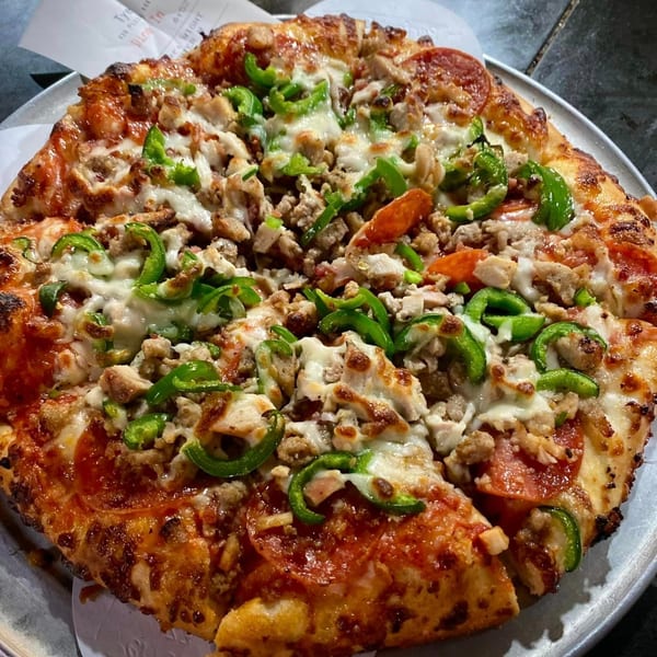 Task Force Pizza Co. pizza with pepperoni, sausage, chicken, and green peppers.