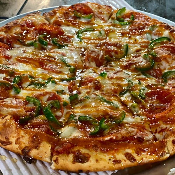 A whole pepperoni and green pepper pizza from Task Force Pizza Co. drizzled with honey.